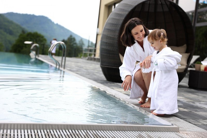 Matka s dieťaťom pri vonkajšom bazéne v areáli hotela Sitno